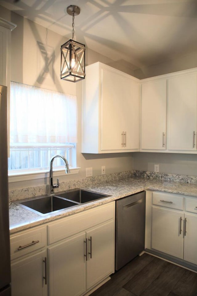 kitchen featuring appliances with stainless steel finishes, dark wood-style flooring, white cabinetry, pendant lighting, and a sink