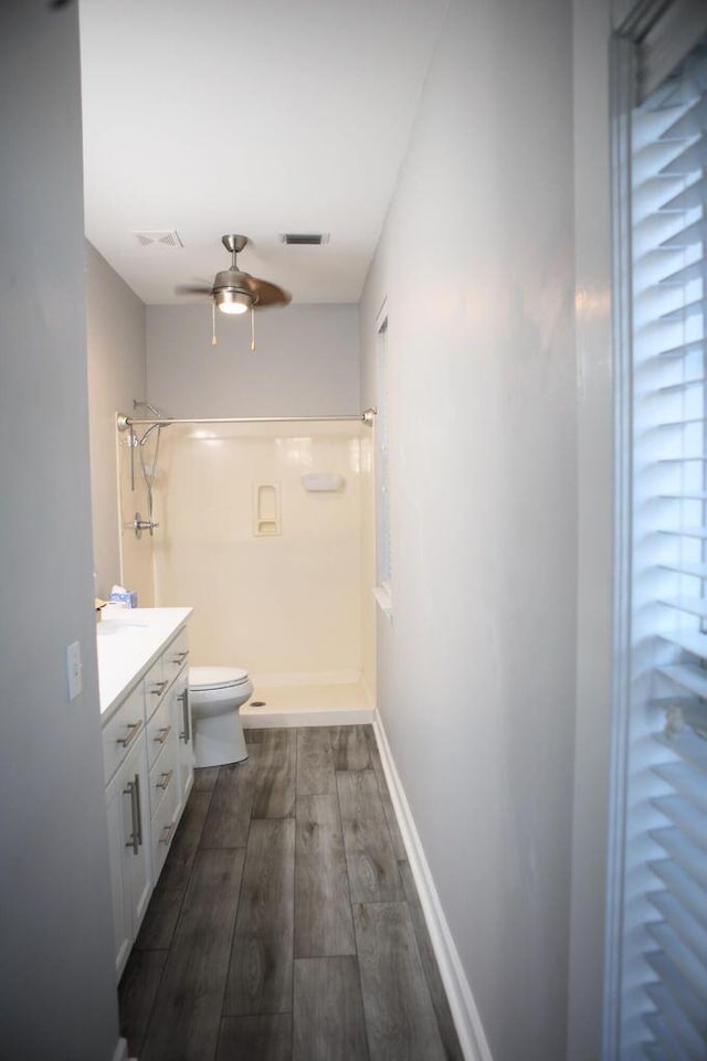 bathroom featuring visible vents, a shower, wood finished floors, and vanity