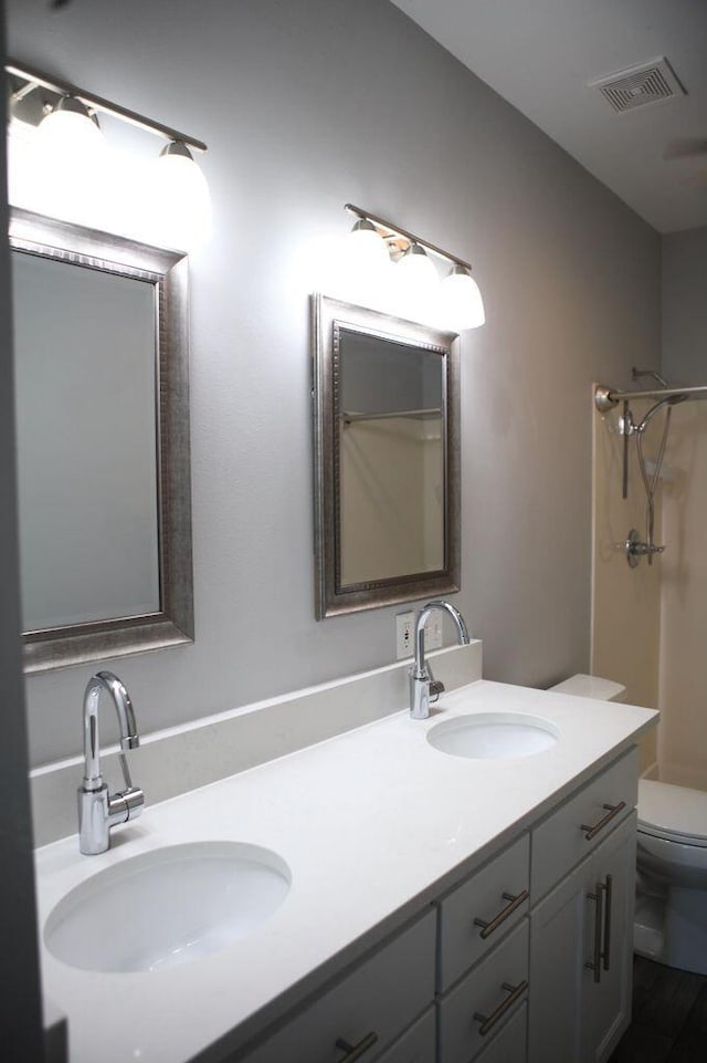 full bathroom featuring toilet, visible vents, walk in shower, and a sink