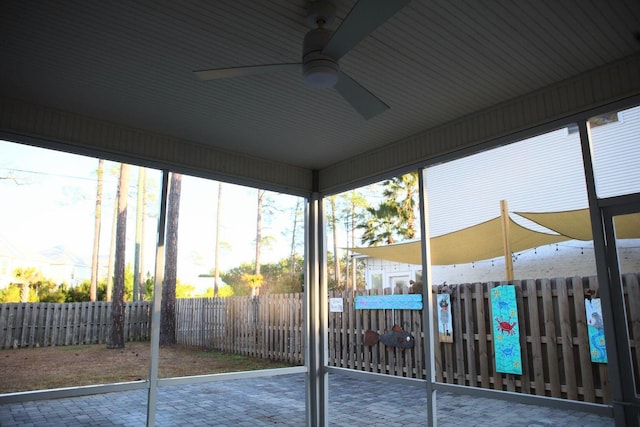 unfurnished sunroom featuring a ceiling fan