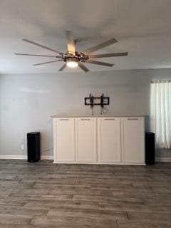 spare room featuring dark wood-style floors, ceiling fan, and baseboards