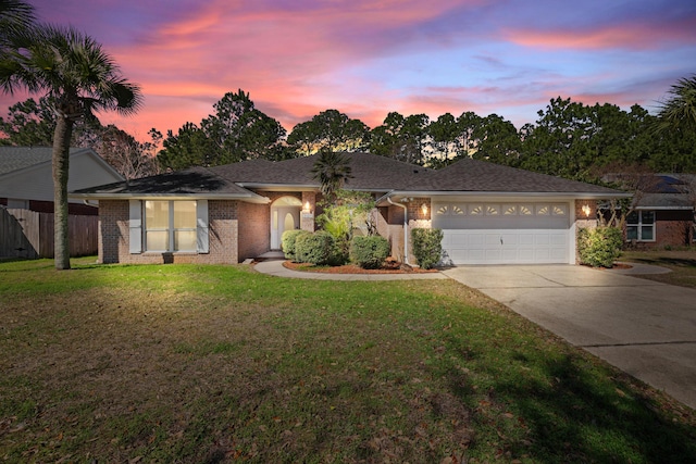 ranch-style house with an attached garage, brick siding, fence, a yard, and driveway