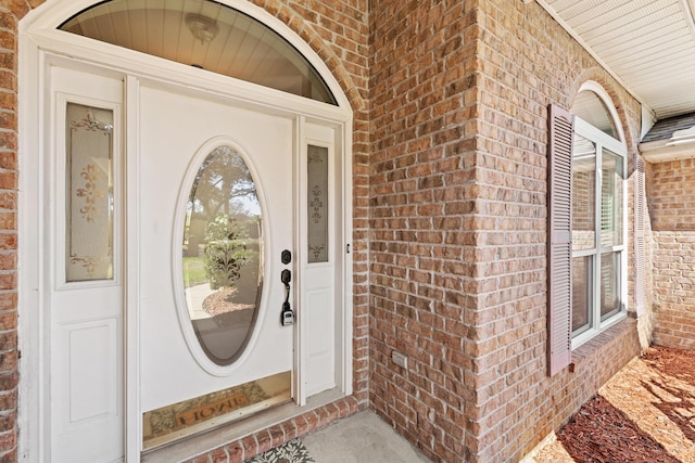 view of exterior entry featuring brick siding