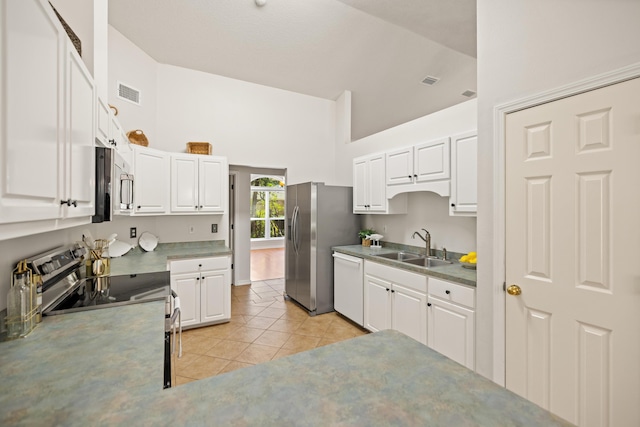 kitchen featuring light tile patterned floors, stainless steel appliances, visible vents, white cabinetry, and a sink