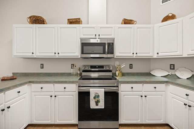 kitchen with appliances with stainless steel finishes and white cabinets