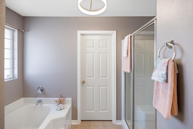 bathroom with a stall shower, tile patterned flooring, a garden tub, and a textured ceiling