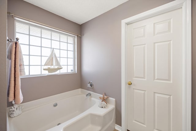 full bath with a textured ceiling and a garden tub