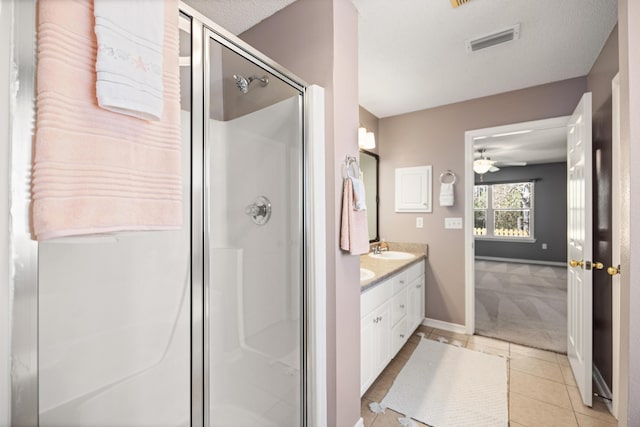 bathroom with double vanity, visible vents, a stall shower, a sink, and tile patterned flooring