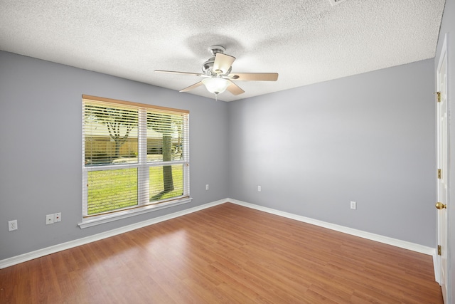 spare room featuring a ceiling fan, a textured ceiling, baseboards, and wood finished floors