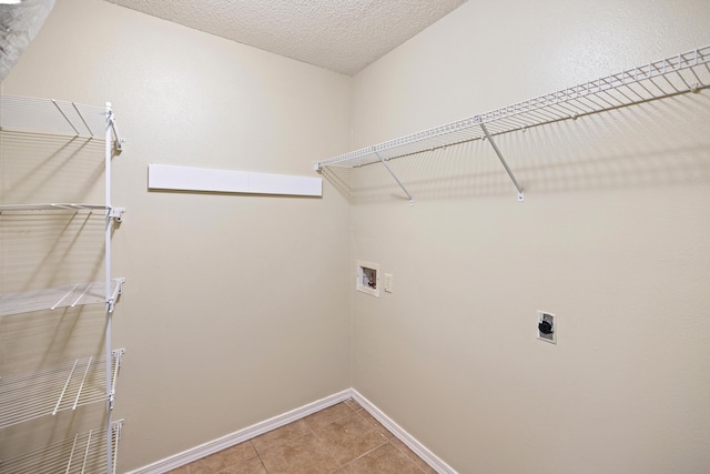 laundry area featuring laundry area, baseboards, a textured ceiling, washer hookup, and electric dryer hookup