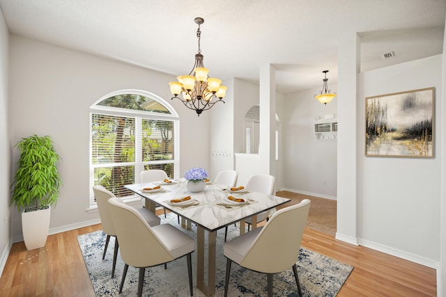 dining area featuring a chandelier, baseboards, and light wood-style floors