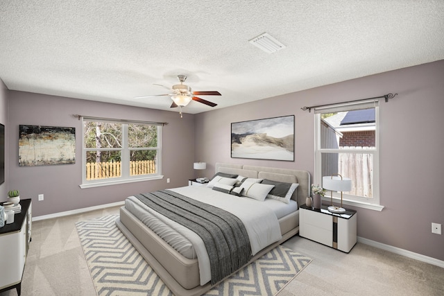 bedroom with baseboards, multiple windows, visible vents, and light colored carpet