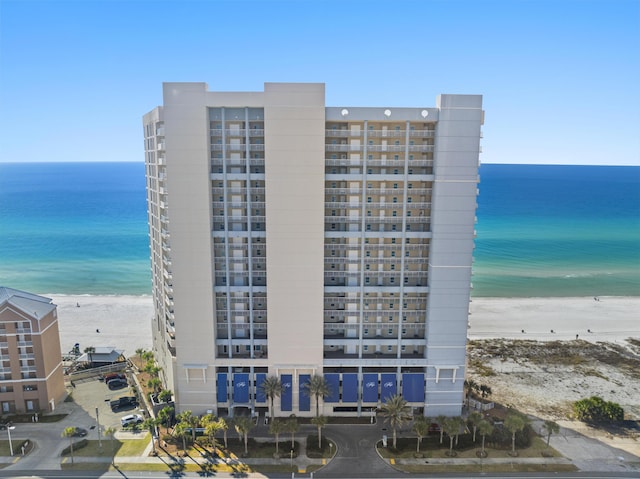 view of property featuring a water view and a beach view