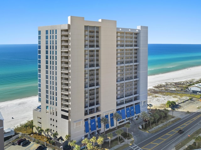 view of building exterior featuring a water view and a view of the beach