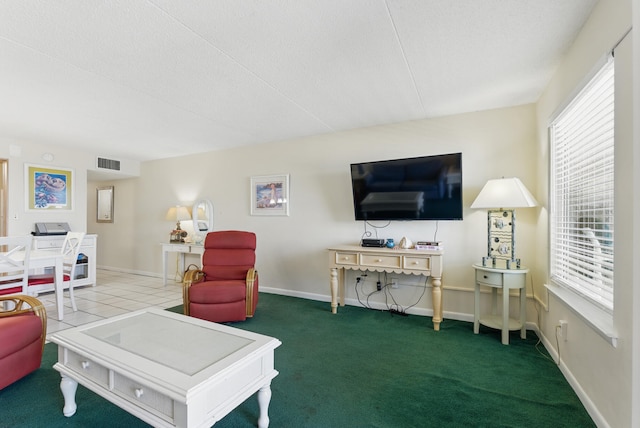 carpeted living room with visible vents, a healthy amount of sunlight, and baseboards