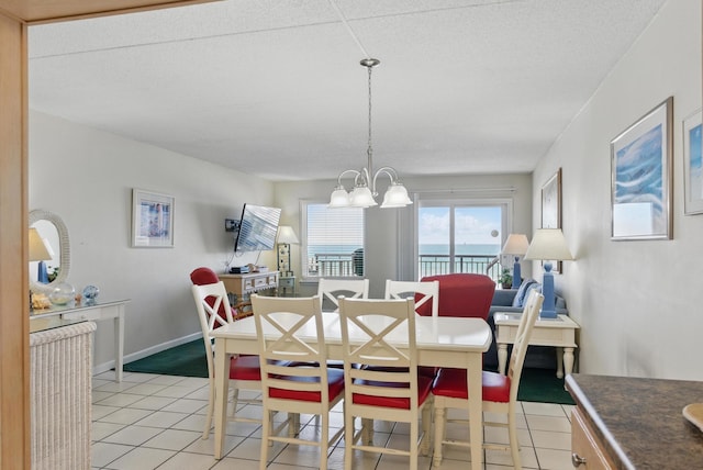 dining room with light tile patterned floors, baseboards, and a notable chandelier