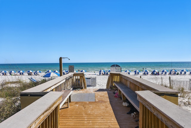 dock area with a beach view and a water view