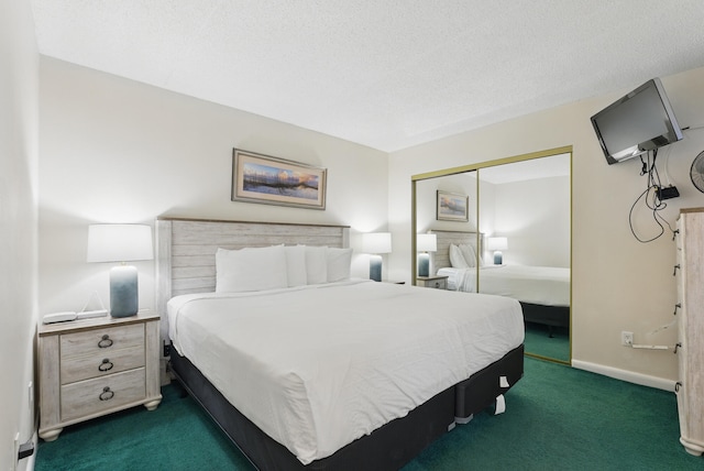 bedroom featuring baseboards, dark colored carpet, a closet, and a textured ceiling