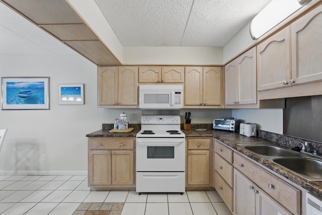 kitchen with white appliances, light tile patterned flooring, light brown cabinetry, a sink, and dark countertops