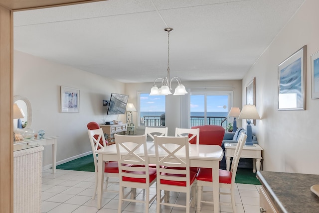 dining space featuring light tile patterned floors, baseboards, and an inviting chandelier