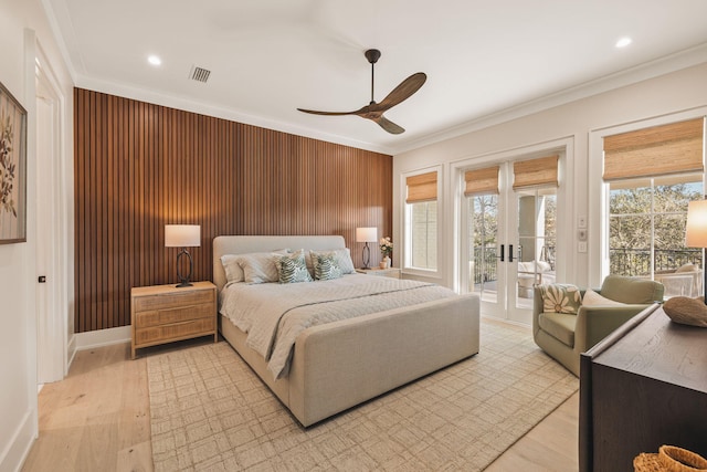 bedroom featuring light wood finished floors, french doors, ornamental molding, and access to exterior