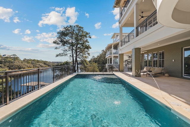 view of pool with a fenced in pool, a water view, a patio, and fence