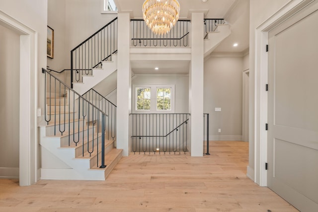 interior space with recessed lighting, a notable chandelier, a high ceiling, wood finished floors, and baseboards