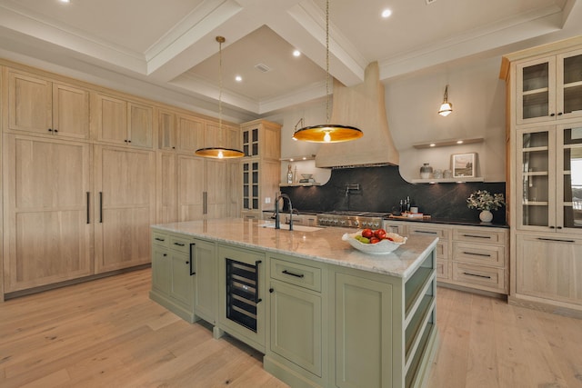 kitchen with beverage cooler, coffered ceiling, a sink, light wood-style floors, and green cabinetry