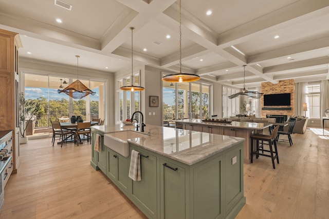 kitchen with a spacious island, visible vents, a sink, and green cabinets