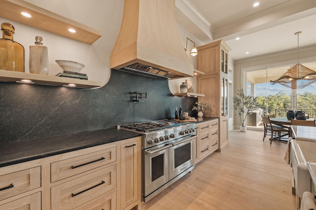 kitchen with range with two ovens, light wood-type flooring, custom exhaust hood, dark countertops, and crown molding