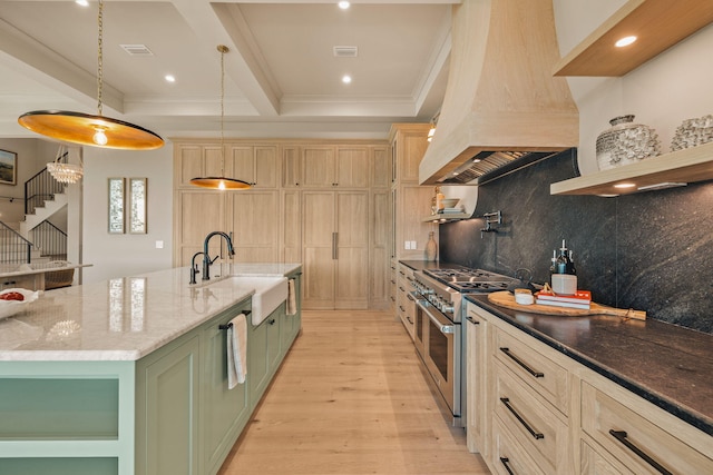 kitchen with stainless steel stove, green cabinetry, a sink, custom exhaust hood, and crown molding