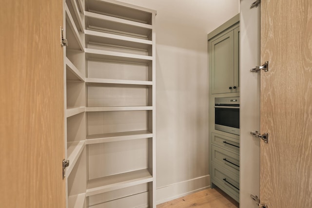 walk in closet with light wood-type flooring