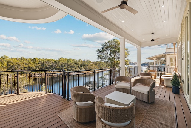 deck featuring ceiling fan and a water view