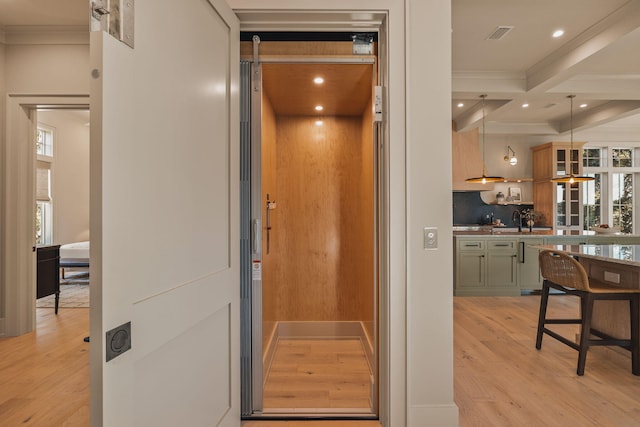 interior space featuring elevator, backsplash, wood finished floors, beam ceiling, and recessed lighting