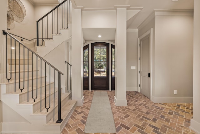 foyer with baseboards, ornamental molding, brick floor, stairs, and recessed lighting