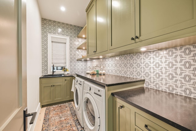 washroom featuring cabinet space, independent washer and dryer, and a sink