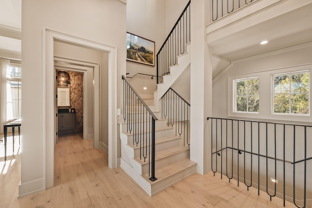 staircase featuring baseboards, wood finished floors, and recessed lighting