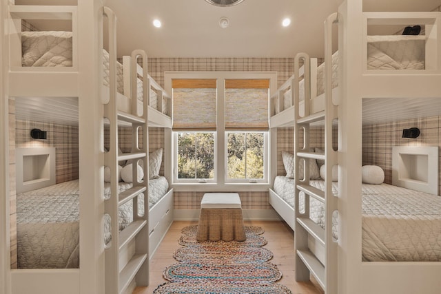 bedroom featuring baseboards, recessed lighting, wood finished floors, and wallpapered walls