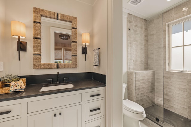 full bathroom with visible vents, vanity, a shower stall, and toilet