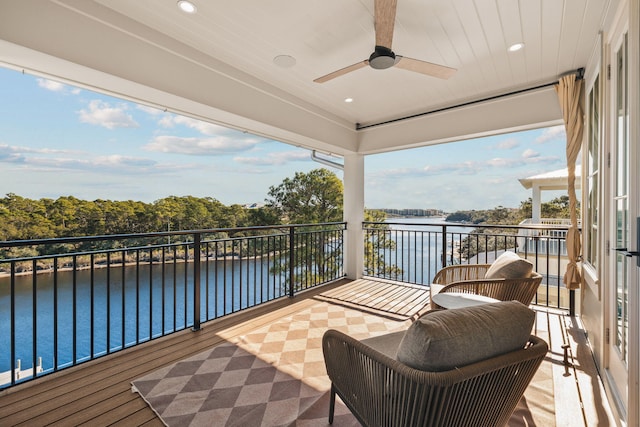 wooden deck featuring a water view and ceiling fan