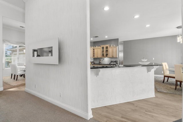 kitchen with glass insert cabinets, dark countertops, pendant lighting, and a peninsula