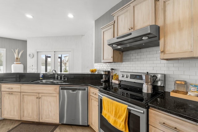 kitchen featuring light brown cabinetry, appliances with stainless steel finishes, a sink, and under cabinet range hood