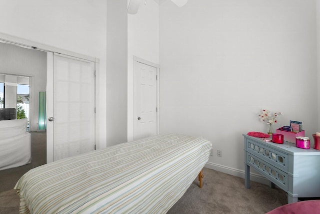 carpeted bedroom featuring a ceiling fan, a high ceiling, and baseboards