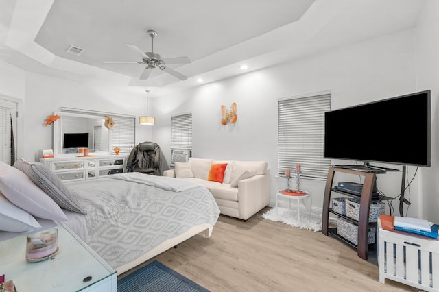 bedroom with visible vents, ceiling fan, a tray ceiling, light wood-type flooring, and recessed lighting