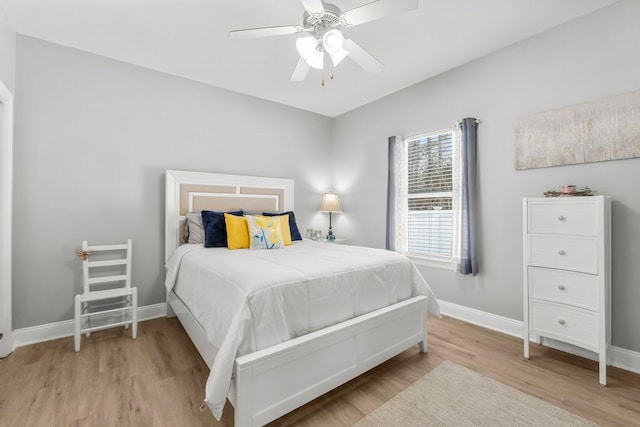 bedroom featuring light wood-style flooring, baseboards, and ceiling fan