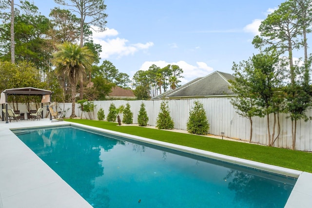 view of swimming pool with a fenced backyard and a lawn