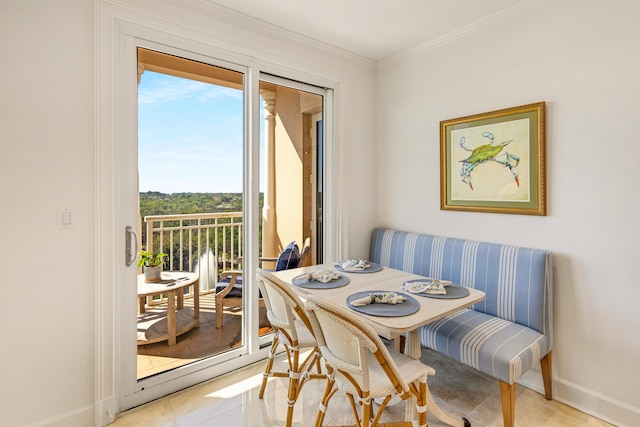 dining space with breakfast area, crown molding, and baseboards