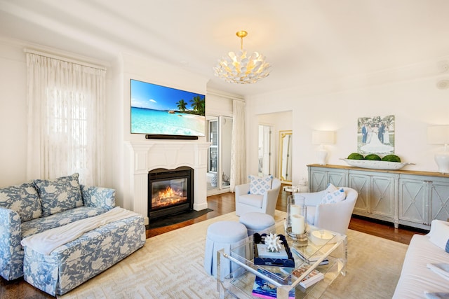 living area with a fireplace with flush hearth, a chandelier, and wood finished floors