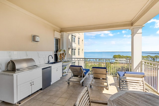 view of patio featuring exterior kitchen, a grill, a water view, and a sink