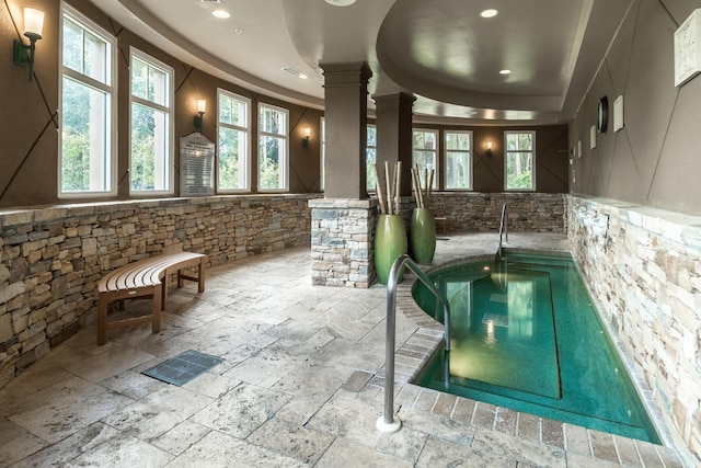 view of pool with an indoor hot tub and decorative columns